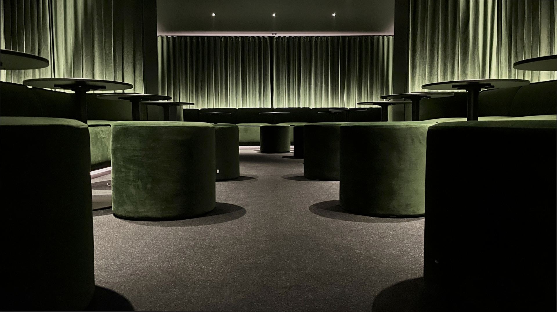 La salle du lieu, banquettes et poufs vert forêt